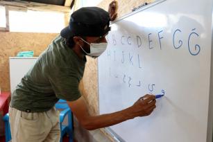 SAVAŞTAN KAÇTI, ÇADIRDA OKUMA YAZMA ÖĞRETİYOR