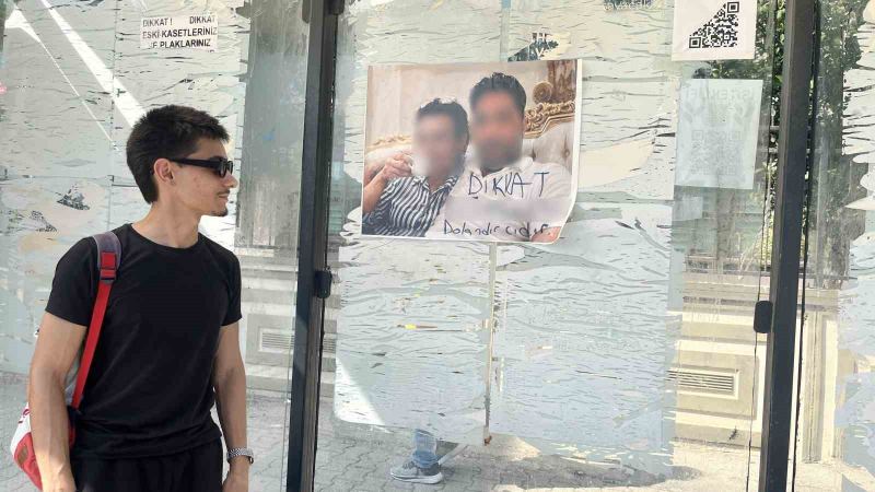 ADANA'DA BİR OTOBÜS DURAĞINA ASILAN VE ÜZERİNDE BİR ERKEK İLE KADININ FOTOĞRAFININ YER ALDIĞI, ERKEĞİN FOTOĞRAFININ ALTINDA "DİKKAT DOLANDIRICIDIR" YAZILI FOTOĞRAF KARESİ DİKKAT ÇEKTİ.