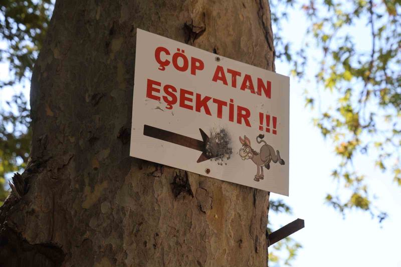 ADANA’NIN FEKE İLÇESİNDE ÇINAR AĞAÇLARININ GÖLGESİNDE, DOĞAL KAYNAK SUYUNUN BULUNDUĞU GEÇİRİMOLUK MESİRE ALANI’NA ASILAN "ÇÖP ATAN EŞEKTİR" YAZILI TABELA DİKKAT ÇEKERKEN, ÇEVREDEKİ ÇÖPLERE TEPKİ GÖSTEREN ÇOCUKLAR DERE YATAĞINDAKİ ATIKLARI TOPLADI.