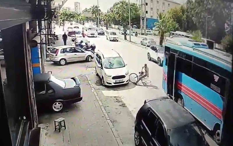 ADANA’DA İKİ KAPISI AÇIK İLERLEYEN HALK OTOBÜSÜNÜN ARKA KAPISI YOL KENARINDAKİ BİSİKLETLİ MUSTAFA TİKEN’E ÇARPTI. O ANLAR GÜVENLİK KAMERASINA SANİYE SANİYE YANSIDI.