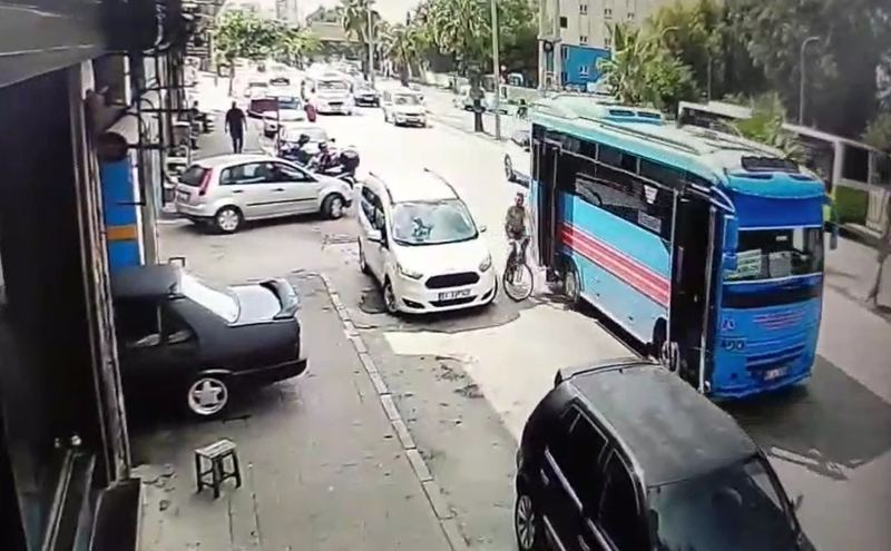 ADANA’DA İKİ KAPISI AÇIK İLERLEYEN HALK OTOBÜSÜNÜN ARKA KAPISI YOL KENARINDAKİ BİSİKLETLİ MUSTAFA TİKEN’E ÇARPTI. O ANLAR GÜVENLİK KAMERASINA SANİYE SANİYE YANSIDI.