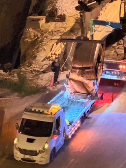 İNŞAAT ÇUKURUNA UÇAN ARAÇ İSE VİNÇ YARDIMIYLA ÇIKARILDI.